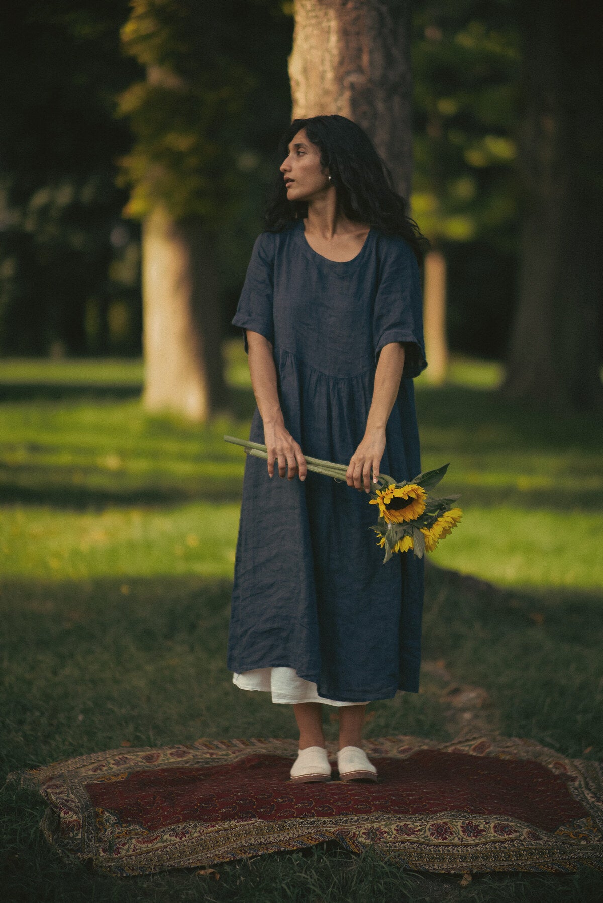 Femme aux tournesols dans un parc, pâpouches aux pieds